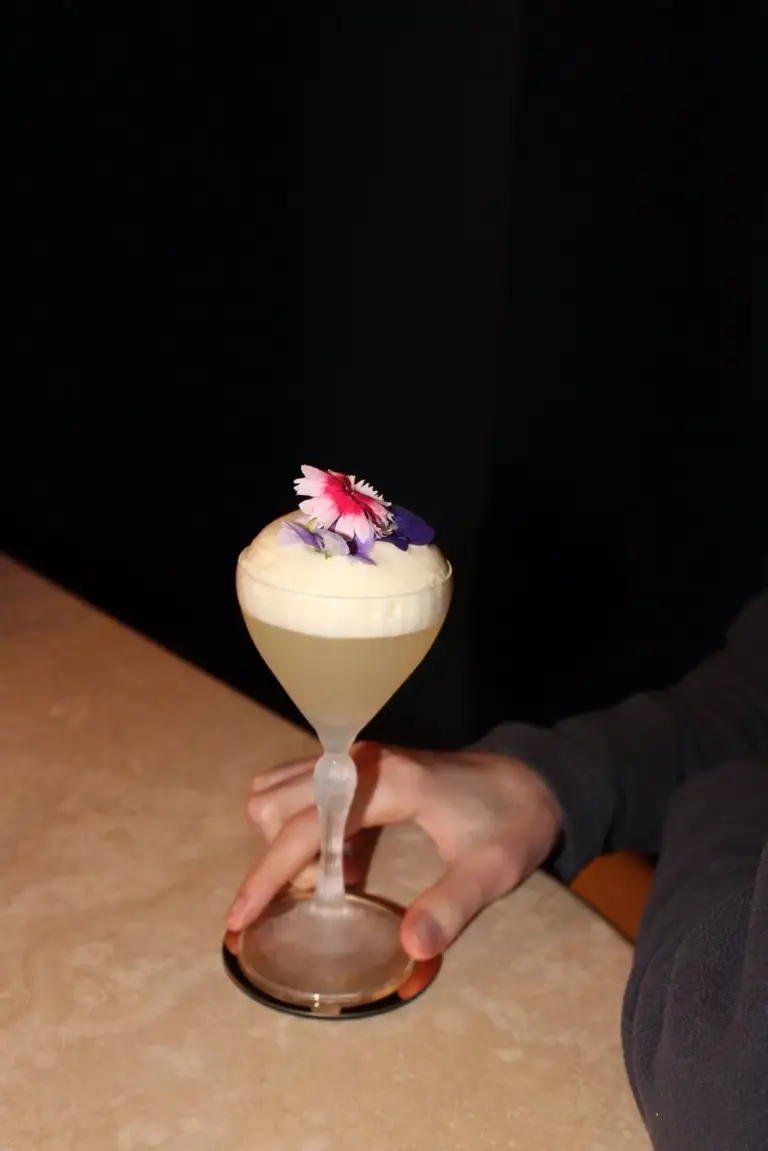 A Beef&Bass cocktail garnished with an edible flower