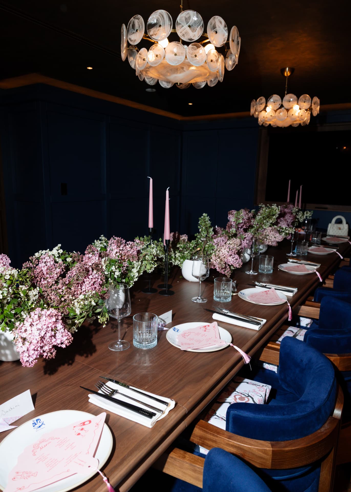 Private dining table set with flowers and candles under glass chandeliers